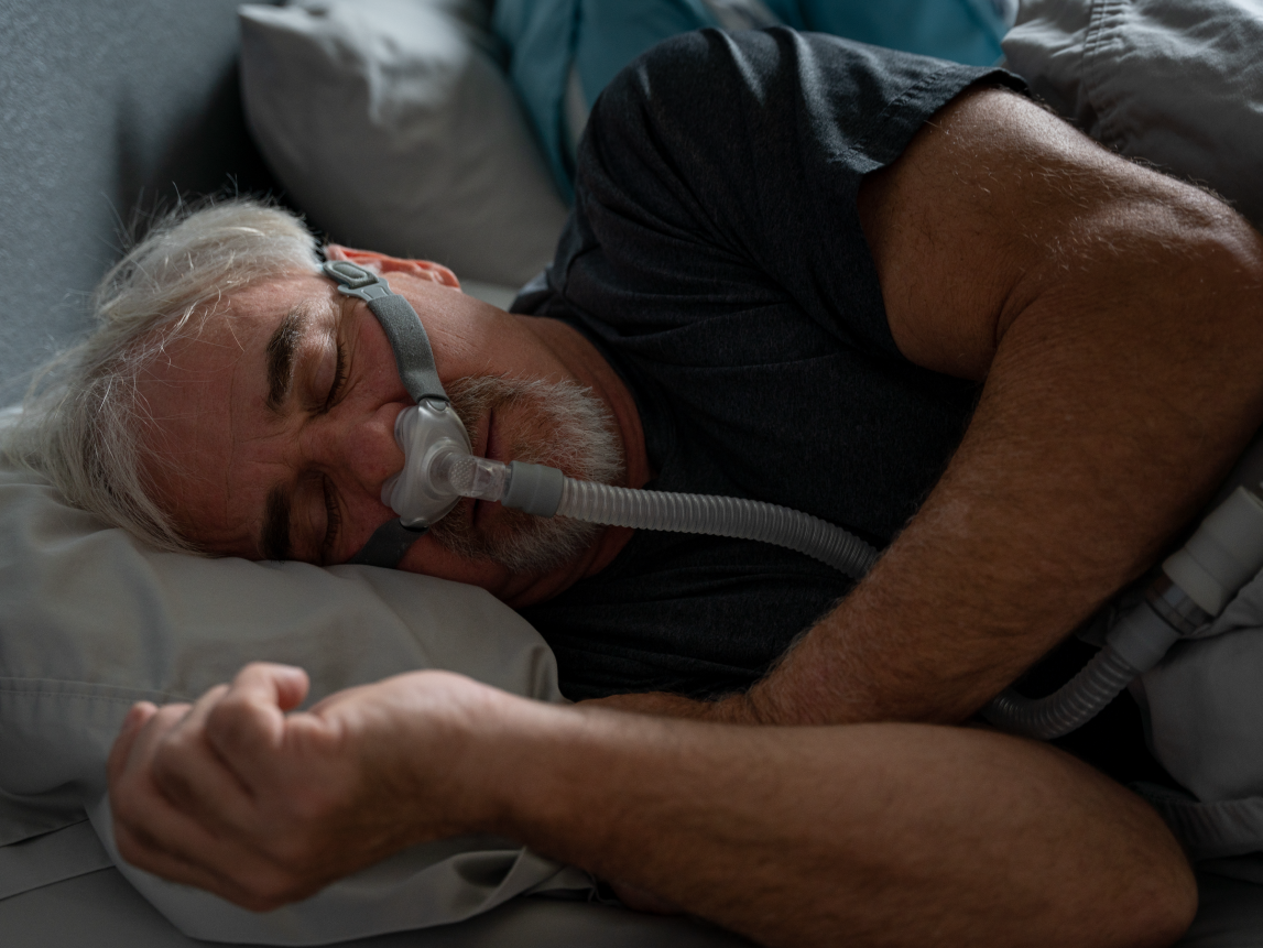 A person with sleep apnea wearing a CPAP machine for breathing assistance.